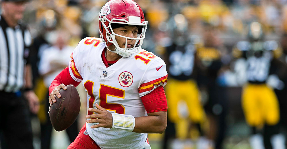 Patrick Mahomes (15) scrambles with the ball