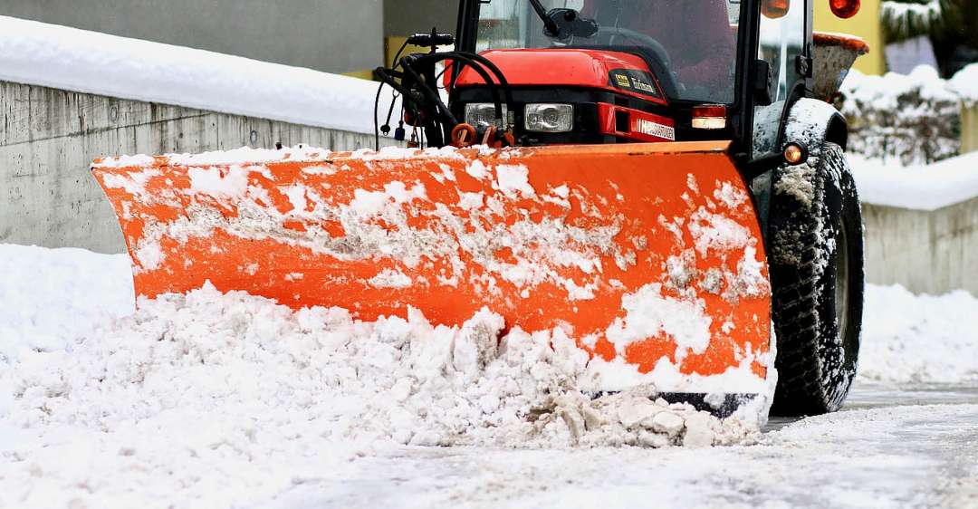 Tractor plowing snow off roads.