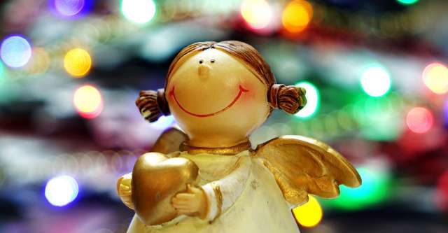 Christmas angel in front of lights.