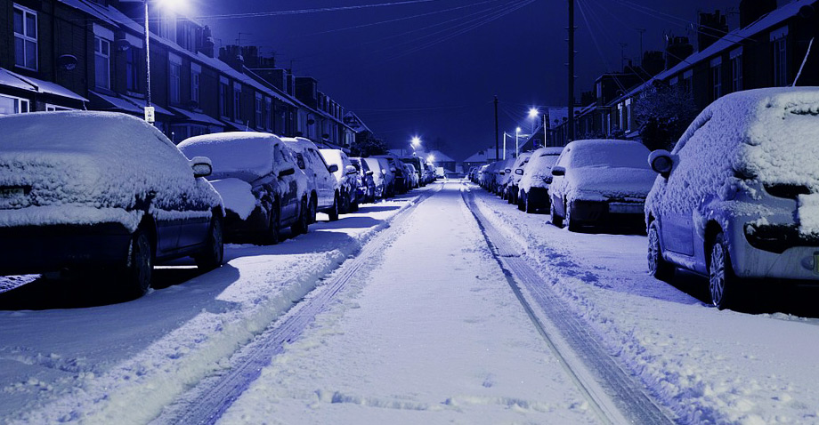 Snow covered road in city.