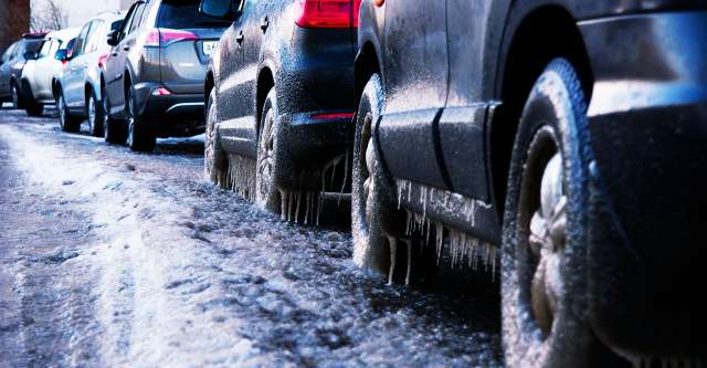 Row of cars with ice on them.