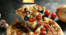 Pizza slice being picked up.