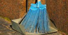 A blue broom and metal dust pan.