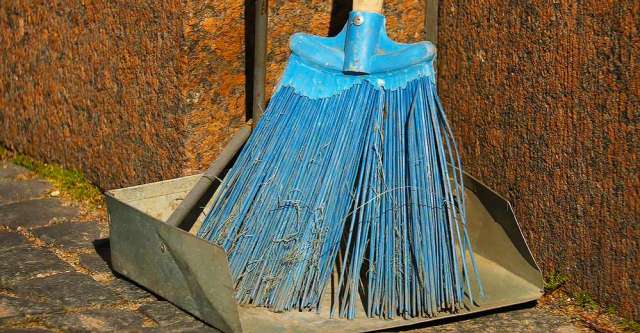 A blue broom and metal dust pan.