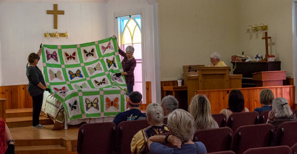 Crowd admires quilt at the 2021 Ozark “Black Gold” Walnut Festival Quilt Show.