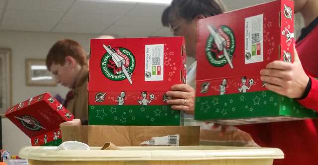 workers stuffing Christmas shoe boxes