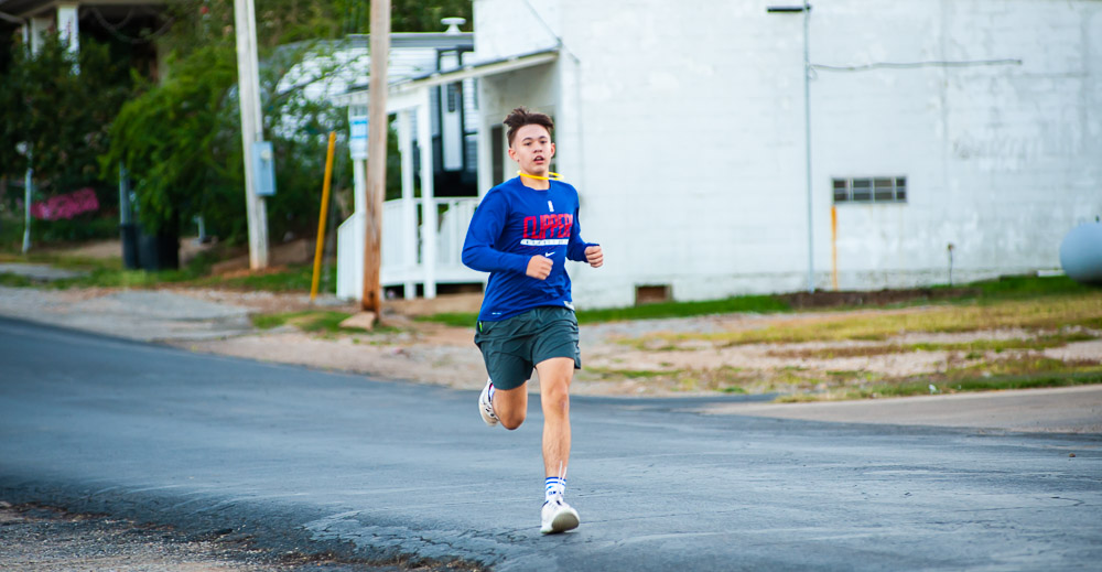 Run the Town for the Gold 5K runner sprinting towards the finish line.