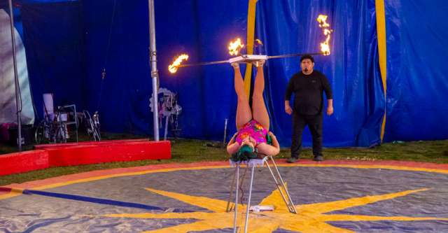 A performer juggles poles of fire on her feet at the Culpepper & Merriweather Circus on April 3, 2023.