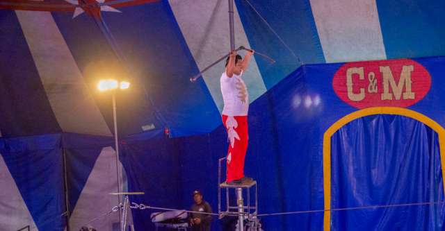 Brandon Romario Perez stands on a chair while he is on a tight rope at the Culpepper & Merriweather Circus on April 3, 2023.