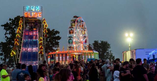 The Ferris Wheel and the Fun Slide illuminated with lights at the Heart of the Ozarks Fair on June 6, 2023.