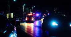 Firetrucks and police cars flash their lights as they drive along the parade route during the 2023 Alton, Missouri, Christmas parade.