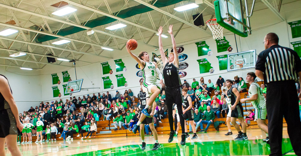 THAYER, MO – DECEMBER 18: Thayer Bobcats Devin Harrington (3) soars through the air with the ball to get a two-pointer during the high school basketball game between the Thayer Bobcats and the Izard County Cougars on December 18, 2023 at the Thayer High School Gym in Thayer, Missouri. (Photo by Amanda Thomas/AltonMo.com)