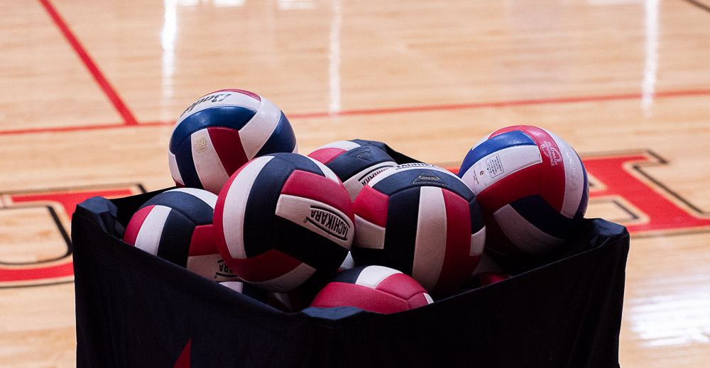 Volleyballs piled up in a bin.