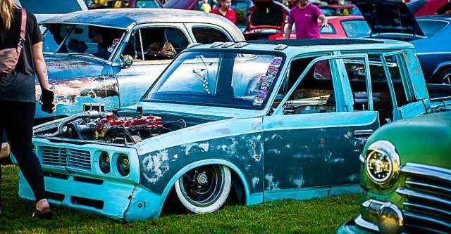 A classic pickup truck sitting low to the ground.