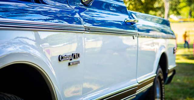A classic blue and white pickup truck at the car show.