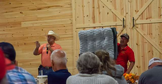 The auctioneer auctioning off a soft dog bed.