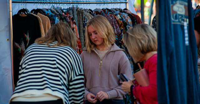 A girl looking at items a vendor had.