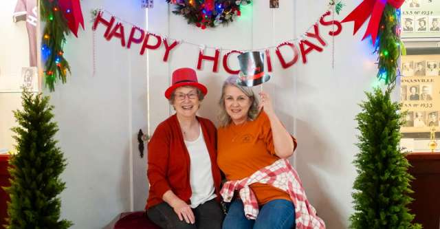 Two ladies posing for a photo at the Christmas photo booth.