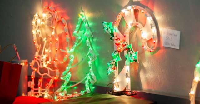 Light-up Christmas decorations propped against a wall.