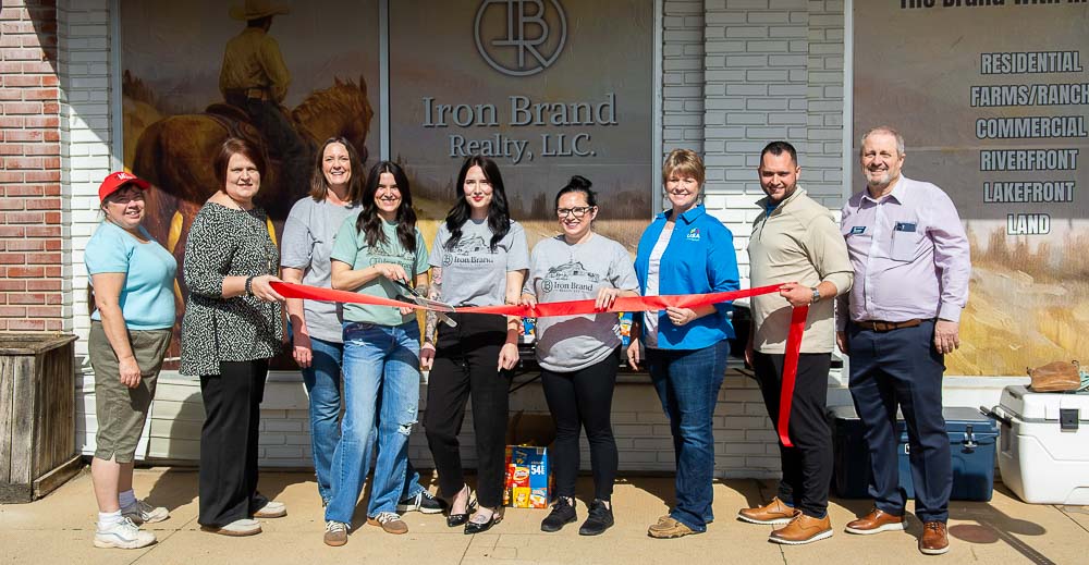 Members from Iron Brand Realty, USA Mortgage, Alton Bank, and AltonMo.com cutting the ribbon at the grand opening.