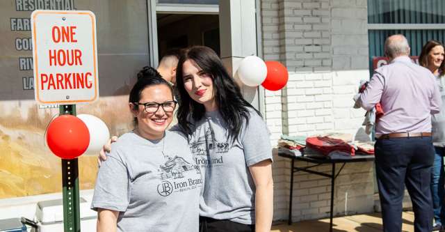 Brittany Madden posing with the owner's wife, Haley Kraft, at Iron Brand Realty's grand opening.