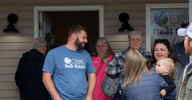 Individuals visiting with locals at the United Country grand opening.
