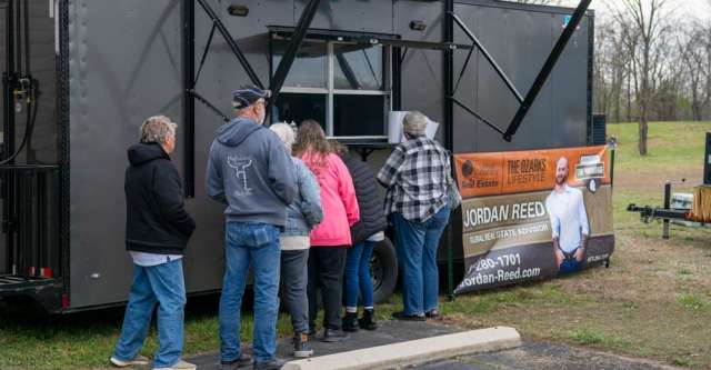 Individuals in line for the pork at United Country's grand opening.