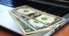 Money laying on a laptop.