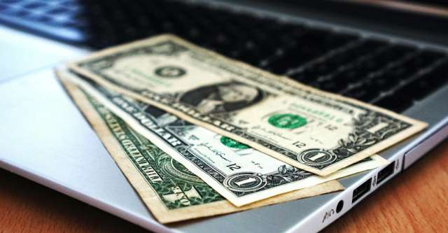 Money laying on a laptop.