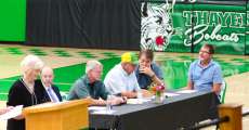 Individuals sitting at a table during the town hall.