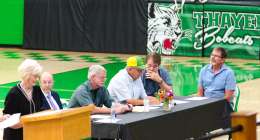 Individuals sitting at a table during the town hall.