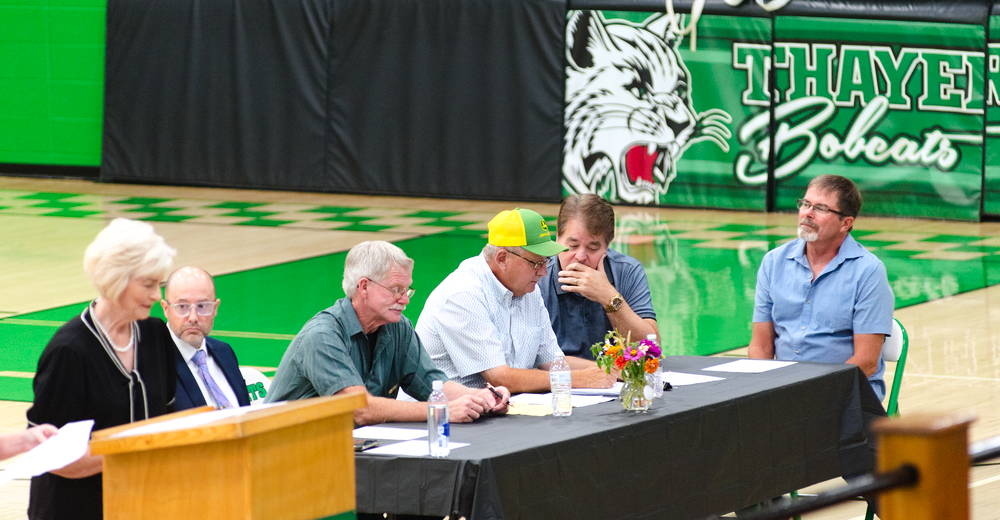 Individuals sitting at a table during the town hall.