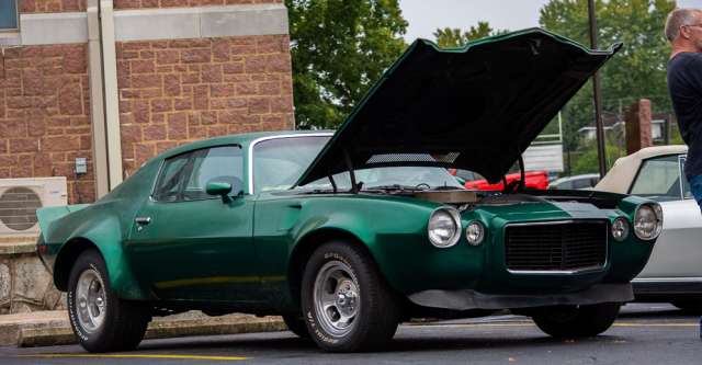 A classic car being shown off at the cruise-in on the square.