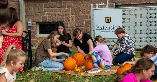 Kids carving pumpkins at the Walnut Festival.